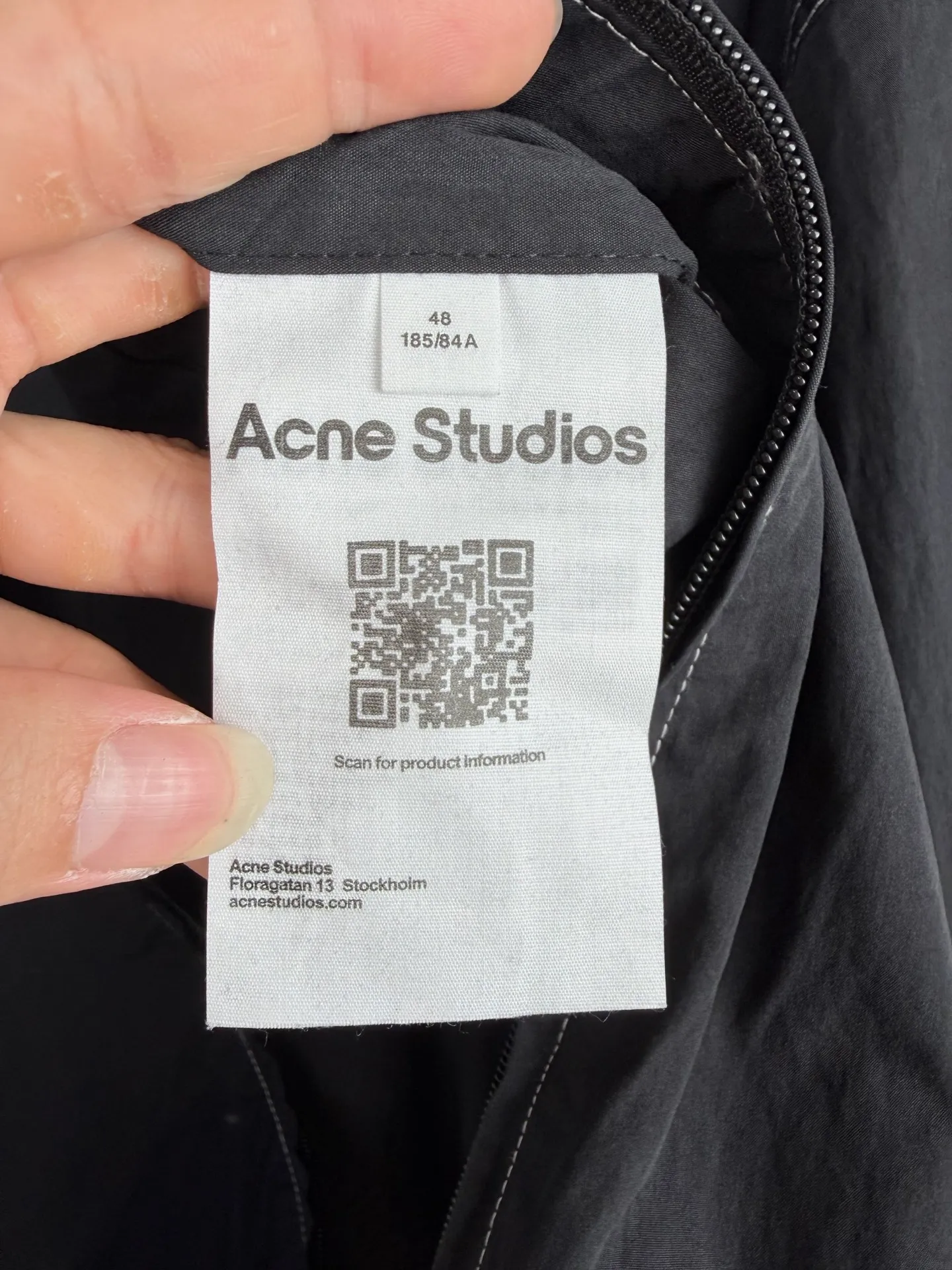 Acne Studios logo-printed hooded jacket. Custom-made Lanxu poplin. Breathable. Comfortable and skin-friendly. Obsidian black dip-dyed body. Native matte texture, calm and restrained. Contrast topstitching is extended along the seams. Architectural lines are used to outline the three-dimensional silhouette of the body. Layers of tension are spread on a dark black background. The hooded silhouette is relaxed and stretched. ACNE STUDIOS STOCKHOLM hot stamping printed static fabric on the back. The light and shadow are looming, restrained and engraved with the Stockholm brand narrative. The full zipper opening and closing is neat and easy. The elasticated hem and cuffs create a relaxed and short silhouette. Integrate Stockholm's minimalist pioneer genes into the functional jacket to interpret the cool and restrained high-end elegance of Northern Europe. Process 1: Using hot stamping printing process. The printing is calibrated through multiple layers. The heat transfer film and high-temperature fusion pigments are used to transfer the pattern on the fabric. High-temperature pressing of the fabric to fix the transfer pattern. Process 2: Template machine bag opening. The preset template guides the position, shape and size of the bag opening. The accuracy ensures the quality of the bag opening effect. Accessories: Customized 1:1 Acne placket zipper. Customized 1:1 Acne pocket zipper. Customized 1:1 Acne snap button. Customized 1:1 Acne trademark. Version: Loose version. Size: 44 46 48 50